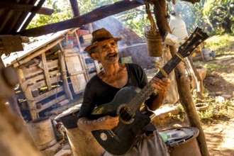 Sugar cane farmer in Valle de los Ingenios plays guitar for the tourists, Trinidad, Cuba, Sancti