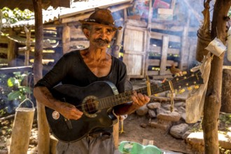 Sugar cane farmer in Valle de los Ingenios plays guitar for the tourists, Trinidad, Cuba, Sancti
