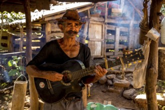 Sugar cane farmer in Valle de los Ingenios plays guitar for the tourists, Trinidad, Cuba, Sancti