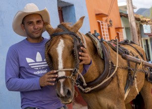 Cuban rider cowboy with his horse in the streets of Trinidad, Trinidad, Cuba, Sancti Spíritus,