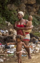 Mother with two children barefoot at a rubbish dump, poverty on the island of Cuba, Trinidad, Cuba,
