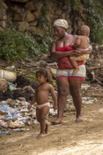 Mother with two children barefoot at a rubbish dump, poverty on the island of Cuba, Trinidad, Cuba,