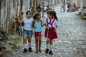 Three girls discussing on the street, Schoolgirls, Children, Street scene in the old town of