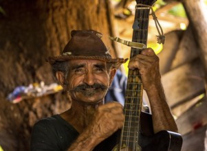 Sugar cane farmer in Valle de los Ingenios plays guitar for the tourists, Trinidad, Cuba, Sancti
