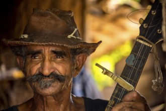 Sugar cane farmer in Valle de los Ingenios plays guitar for the tourists, Trinidad, Cuba, Sancti