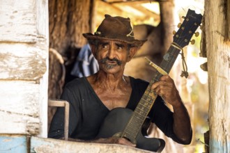 Sugar cane farmer in Valle de los Ingenios plays guitar for the tourists, Trinidad, Cuba, Sancti