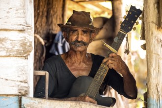 Sugar cane farmer in Valle de los Ingenios plays guitar for the tourists, Trinidad, Cuba, Sancti