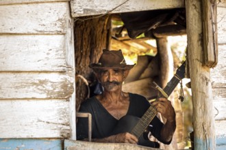 Sugar cane farmer in Valle de los Ingenios plays guitar for the tourists, Trinidad, Cuba, Sancti
