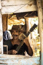 Sugar cane farmer in Valle de los Ingenios plays guitar for the tourists, Trinidad, Cuba, Sancti