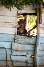 Sugar cane farmer in Valle de los Ingenios plays guitar for the tourists, Trinidad, Cuba, Sancti