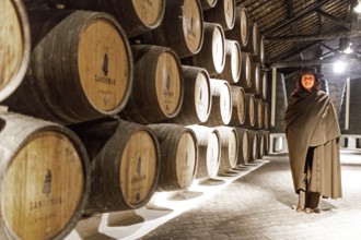 Classic tour guide with student dress, port wine barrels, wine cellar of the Sandemann winery in