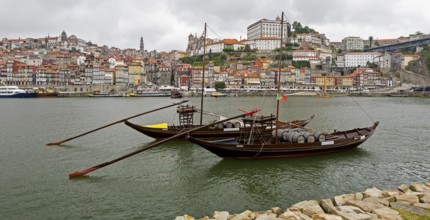 Historic wine transport ships on the Douro, colourful houses on the banks of the Douro in the