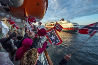 Tourists at the ship's railing, ship MS Finnmarken, Norwegian flags, Mehamn, Finnmark, Norway,