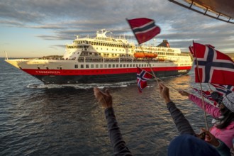 Tourists at the ship's railing, ship MS Finnmarken, Norwegian flags, Mehamn, Finnmark, Norway,
