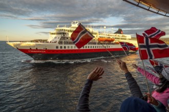 Tourists at the ship's railing, ship MS Finnmarken, Norwegian flags, Mehamn, Finnmark, Norway,