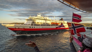 Tourists at the ship's railing, ship MS Finnmarken, Norwegian flags, Mehamn, Finnmark, Norway,