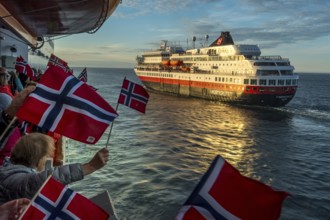 Tourists at the ship's railing, ship MS Finnmarken, Norwegian flags, Mehamn, Finnmark, Norway,