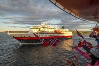 Tourists at the ship's railing, ship MS Finnmarken, Norwegian flags, Mehamn, Finnmark, Norway,