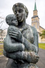 Statue Mother and Child, Church Square, Tromsø Cathedral in the background, Tromsø, Troms, Norway,