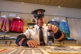 Crew member stamps the mail on the mailboat, postman, ship officer, postal employee, postcard