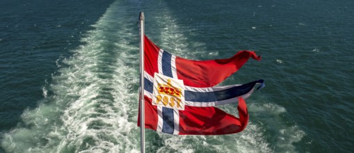 The post symbol on Norwegian flag of a Hurtigruten ship, foaming spray, Trondheimfjord, Agdenes,
