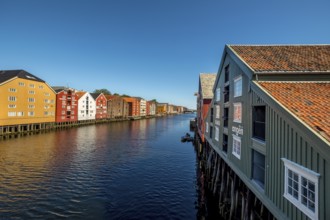 Warehouse city, picturesque colourful houses and commercial buildings on the river Nidelva, pile