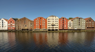 Warehouse city, picturesque colourful houses and commercial buildings on the river Nidelva, pile