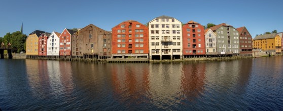 Warehouse city, picturesque colourful houses and commercial buildings on the river Nidelva, pile