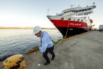 Sailor, sailor mooring the ship MS Polarlys at the quay, harbour bollard with mooring line, Molde