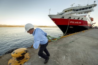 Sailor, sailor mooring the ship MS Polarlys at the quay, harbour bollard with mooring line, Molde