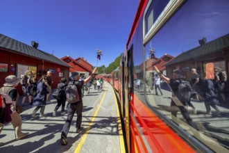 Tour guide reflected in the train window, tourists on the platform, Bergen railway station, Myrdal,