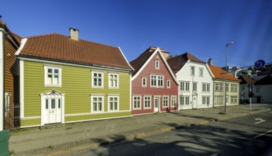 Colourful row of wooden houses in the city of Bergen, street with traffic lights, street lamp,