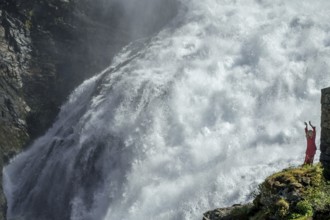 Woman dressed in red is a Huldra, fairy, legendary figure, Kjosfossen waterfall, waterfall near