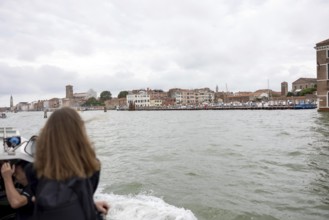 Venice, Italy - 2 September 2025: A woman takes a photo with her mobile phone on the way to the