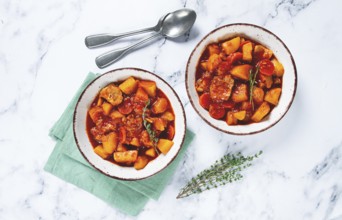Meat goulash with potatoes and carrots, sweet peppers, in a saucepan, top view, traditional