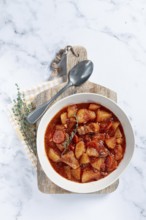 Meat goulash with potatoes and carrots, sweet peppers, in a saucepan, top view, traditional