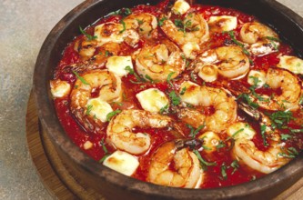 Saganaki with shrimp, in a clay pan, Greek dish, shrimp in tomato sauce, feta cheese, homemade, no
