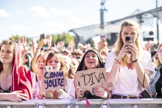 Festival visitors celebrate with Conan Gray at the Superbloom Festival and hold up signs, day 2 in