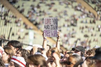 A festival visitor holds a sign I Love You More Than Free WiFi, Day 2 in the Olympic Park, Munich,