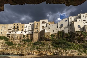 Houses above the cliffs on the town beach Spiaggia Llama Monachile in Polignano a Mare, Apulia,
