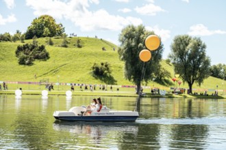 Festival visitors ride a pedal boat at the Superbloom Festival, Day 2 in the Olympic Park, Munich,