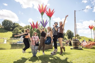 Festival-goers jump into the air at the Superbloom Festival, day 2 in the Olympic Park, Munich,