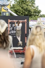 A visitor does pull-ups with make-up at the Superbloom Festival, Day 2 in the Olympic Park, Munich,