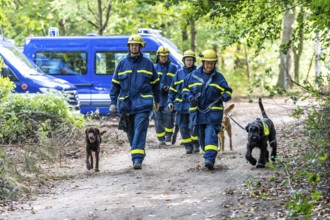 Dog handlers with rescue dogs from the Specialist Locating Group get ready for action, the sniffer