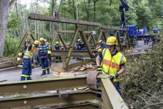 Construction of a temporary bridge over a slipped road crossing a stream, by the bridge