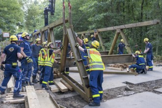 Construction of a temporary bridge over a slipped road crossing a stream, by the bridge