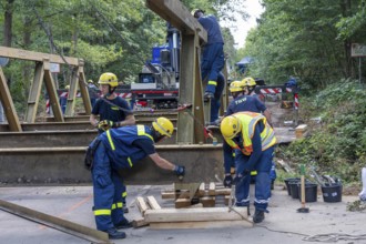 Construction of a temporary bridge over a slipped road crossing a stream, by the bridge