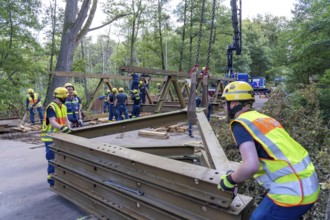 Construction of a temporary bridge over a slipped road crossing a stream, by the bridge