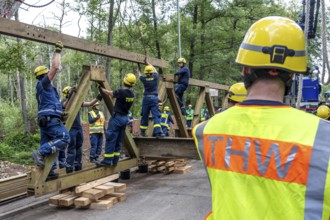 Construction of a temporary bridge over a slipped road crossing a stream, by the bridge