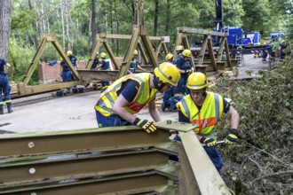 Construction of a temporary bridge over a slipped road crossing a stream, by the bridge